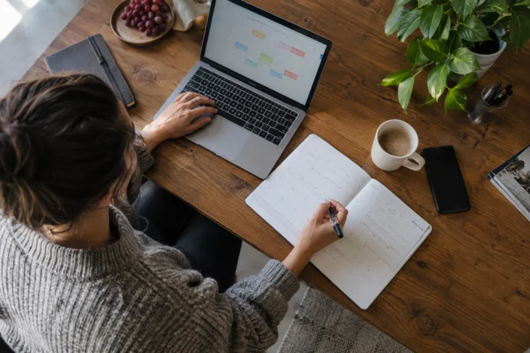 A woman plans an appointment using a laptop and calendar
